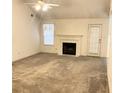 Open living room featuring neutral carpet, a ceiling fan, and a fireplace at 3041 Regal Dr, Mcdonough, GA 30253