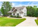 Side view of home featuring well-manicured lawn and a long driveway leading to an attached garage at 510 Black Horse Cir, Canton, GA 30114