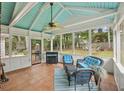 Inviting screened porch with ceiling fan, blue cushioned seating, and views of the landscaped backyard at 4624 Stonehenge Dr, Atlanta, GA 30360