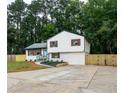 Charming two-story home featuring a bright blue front door, fresh landscaping, and a newly paved driveway at 6050 Randy Ln, Ellenwood, GA 30294
