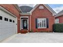 Close-up of the home's entrance, showcasing the brick facade, garage, and well-maintained landscaping at 2324 Blackberry Ct, Snellville, GA 30078