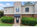 Charming townhouse exterior with brick accents, black awning and lush green landscaping at 3301 Henderson Mill Rd # Aa3, Atlanta, GA 30341