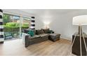 Bright living room with gray sectional sofa, light wood floors, and sliding glass doors to patio at 3301 Henderson Mill Rd # Aa3, Atlanta, GA 30341