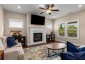 Cozy living room with fireplace, ceiling fan, plush seating, and large windows offering natural light at 508 Windy Ridge Ct, Canton, GA 30114