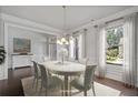 Elegant dining room with large windows, stylish chandelier, and seating for six at 2050 Poplar Ridge Pl, Cumming, GA 30040