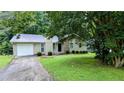 Single-story home with stone accents, complemented by a well-maintained lawn and mature trees at 3900 Ferncliff Rd, Snellville, GA 30039