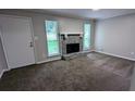 Cozy living room with fireplace, neutral paint, plush carpeting, and bright windows at 3900 Ferncliff Rd, Snellville, GA 30039