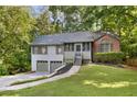 Charming split-level home featuring a two-car garage, screened porch entry, and mature trees at 3902 Robin Court Ct, Acworth, GA 30101