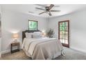 Cozy bedroom with neutral carpet, gray upholstered headboard, ceiling fan, and natural lighting at 911 Oakland Sw Dr, Atlanta, GA 30310