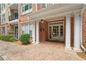 Close-up of a brick building entrance with white columns and a well-manicured garden at 2303 Stratford Commons Commons, Decatur, GA 30033