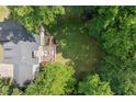 Aerial view of a home with a deck, a large lawn, and mature trees providing privacy at 4392 Windsor Oaks Cir, Marietta, GA 30066