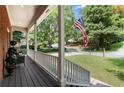 Inviting covered front porch with classic railings and an American flag, showcasing a welcoming entrance at 4392 Windsor Oaks Cir, Marietta, GA 30066