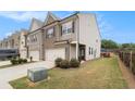 A row of townhomes with a grassy backyard and wood fence at 2700 Norwich Trce, Snellville, GA 30078