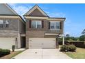 Two-story townhome with brick and siding, attached garage, and well-maintained lawn at 2700 Norwich Trce, Snellville, GA 30078
