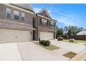 Side view of the two-story townhome showing the driveway, landscaping, and fenced backyard at 2700 Norwich Trce, Snellville, GA 30078