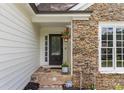Inviting front porch featuring stone details, decorative plants and a stylish front door at 4816 Morning Chase Nw, Acworth, GA 30102