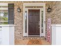 Elegant entryway with a dark wood front door, sidelights, and a brick surround at 1461 Radstone Dr, Lawrenceville, GA 30044