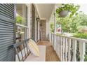 Inviting covered front porch with seating, brick flooring, and a decorative hanging plant at 1461 Radstone Dr, Lawrenceville, GA 30044