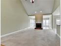 Spacious living room with a fireplace, neutral carpet, and large windows for ample light at 3426 Olivia Grace Way, Dacula, GA 30019