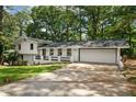 Exterior view of a beautifully renovated home showcasing its brick accents, wide driveway, and attached garage at 4214 Williamsburg Dr, College Park, GA 30337