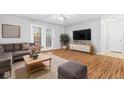 Bright living room features wood flooring, a large sectional, and natural light from the french doors at 106 Brighton Pt, Sandy Springs, GA 30328
