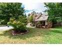 Landscaped front yard featuring mature trees, green grass, and a charming two-story home at 1336 Nathan Mauldin Dr, Lawrenceville, GA 30043