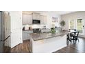 Modern kitchen with stainless steel appliances, granite countertops, a central island, and stylish gray cabinetry at 7814 Messina Ct, Lithia Springs, GA 30122