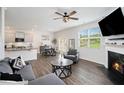 Open-concept living room features a cozy fireplace, modern furnishings, and seamless access to the kitchen and dining area at 7814 Messina Ct, Lithia Springs, GA 30122
