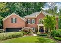 Elegant brick home showcasing manicured lawn, mature landscaping, and attached garage at 1676 Grove Park Way, Decatur, GA 30033