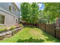 Well-maintained backyard with lush green lawn, a stone retaining wall, and a privacy fence at 175 Centennial Trce, Roswell, GA 30076