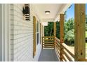 Inviting front porch with wood railing, stylish light fixture, and white brick exterior at 3013 Michael Sw Dr, Marietta, GA 30060