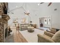 Bright living room boasts stone fireplace, high ceilings with fan, and view to the dining and kitchen areas at 4016 Dover Ave, Alpharetta, GA 30009