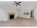 Open-concept living room with fireplace, light wood floors, and open access to the kitchen at 404 Hawkstone Way, Alpharetta, GA 30022