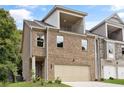 Charming brick townhome with a two-car garage and a balcony on the second floor at 5715 Rocky Falls Drive, Suwanee, GA 30024