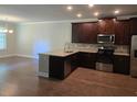 Modern kitchen with granite countertops, stainless steel appliances, and dark wood cabinets at 5715 Rocky Falls Drive, Suwanee, GA 30024