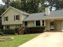 Inviting exterior showcases a well-manicured lawn, covered carport, and convenient access with stairs leading to the entrance at 1380 Ashbrook Dr, Lawrenceville, GA 30043