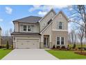 Charming two-story home with stone accents, gray shutters, and a well-manicured lawn at 4770 Briscoe Dr, Cumming, GA 30028