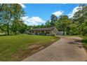 Landscaped front yard leading to a charming single-story home with a long driveway and detached garage at 2089 Christian Se Cir, Conyers, GA 30013
