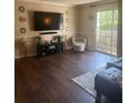 Living room featuring wood floors, modern decor, and sliding glass door at 3120 Seven Pines Court # 203, Atlanta, GA 30339