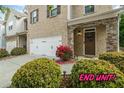 Beautiful brick end-unit townhome featuring a two-car garage and lush landscaping at 2860 Cooper Brook Dr, Snellville, GA 30078