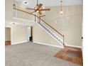 Spacious living room featuring high ceilings, a staircase with white railings, and neutral carpeting at 4000 Mcpherson Drive Dr, Acworth, GA 30101