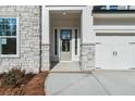 Welcoming front porch featuring stone accents and a modern glass front door, creating a stylish entry at 4480 Beechnut Cir, Cumming, GA 30028