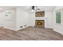 Bright living room with stone fireplace, modern ceiling fan, and beautiful wood-look floors at 4030 Tanglewood Rd, Snellville, GA 30039