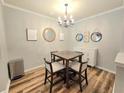 Chic dining room with modern chandelier, square wood table and four padded chairs at 1975 Nocturne Dr # 2206, Alpharetta, GA 30009