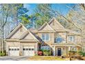 Charming two-story home with a three-car garage and stone detailing on the exterior at 380 Victorian Ln, Duluth, GA 30097
