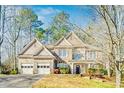 Charming two-story home with a three-car garage and stone detailing on the exterior at 380 Victorian Ln, Duluth, GA 30097