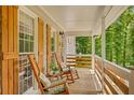 Cozy front porch featuring rocking chairs, wood railing, and natural light creating a relaxing outdoor space at 425 Shelby Ln, Hiram, GA 30141