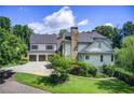 View of home's roof, chimney, three-car garage, landscaped lawn, and siding that gives this home curb appeal at 4559 Paradise Shoals Se Rd, Atlanta, GA 30339