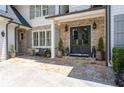 Inviting front porch with stone accents, double doors, bench, matching lanterns, and manicured landscaping at 4559 Paradise Shoals Se Rd, Atlanta, GA 30339