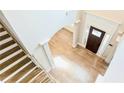 High angle of light-colored wooden stairs that meet an entryway with light wood floors at 5381 Front Runner Ct, Sugar Hill, GA 30518
